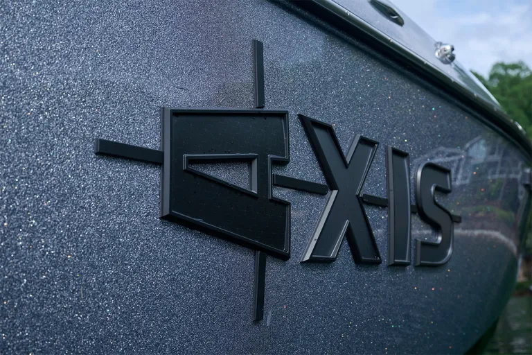 Detail of the raised black Axis logo against the T235's sparkling gunmetal metalflake gelcoat, with a hexagon texture inside the letters.