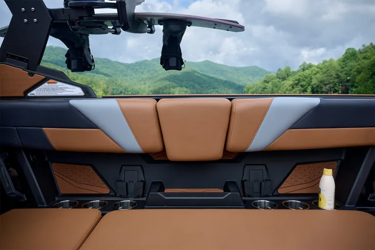 Detail of the Axis T235's rear lounge seat back with two wireless phone chargers and stainless cup holders, a wakeboard racked overhead.